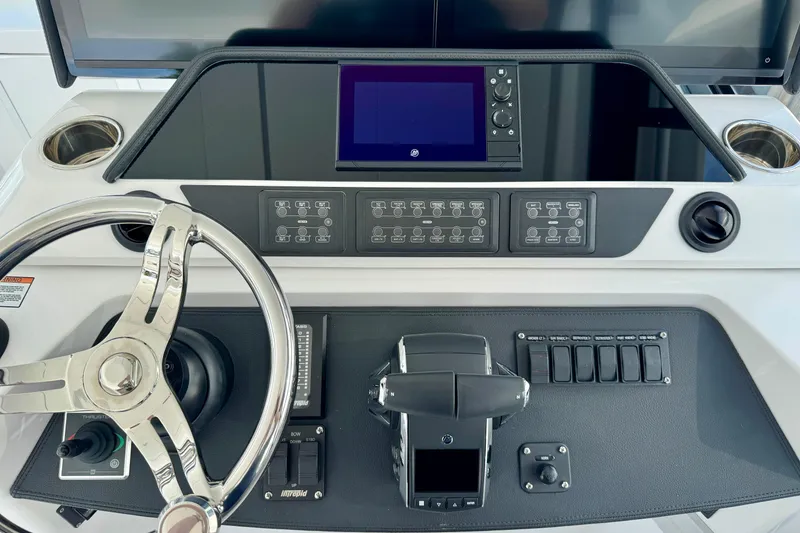 Slide: The Image of Control panel of 2026 Intrepid 50 Evolution boat with steering wheel and navigation controls. - 9