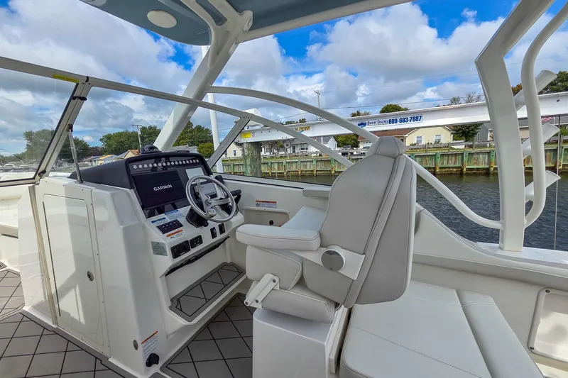 Slide: The Image of 2024 World Cat 296 DC boat interior with luxurious seating on calm water. - 18