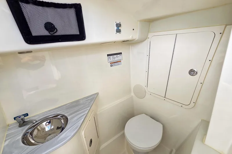 Slide: The Image of 2024 World Cat 296 DC boat interior with steering wheel, dashboard, and open water view. - 19