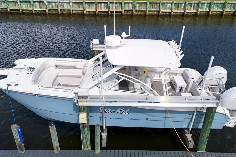 Slide: The Image of 2024 World Cat 296DC boat with twin Yamaha engines docked on water. - 2