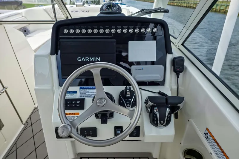 Slide: The Image of 2024 World Cat 296DC boat helm with Garmin navigation system and controls. - 23