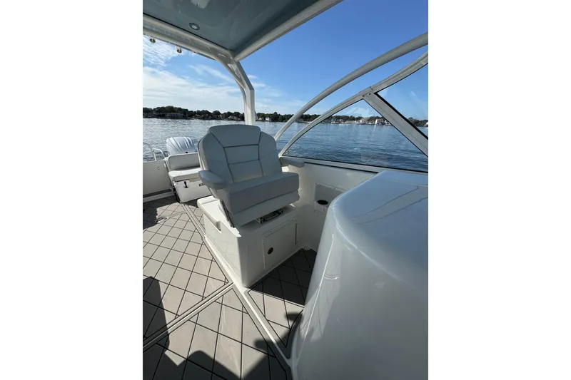 Slide: The Image of 2024 World Cat 296 DC boat interior with seating, overlooking calm waters. - 27