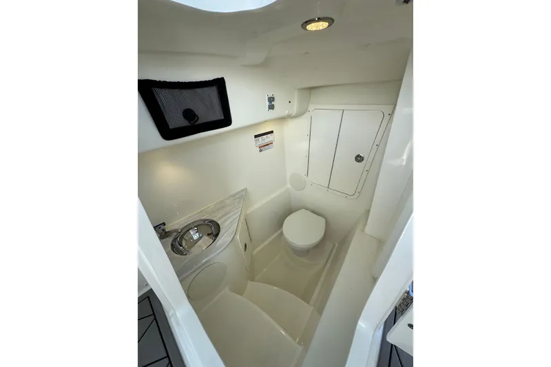 Slide: The Image of 2024 World Cat 296 DC boat interior with compact bathroom, featuring toilet and sink. - 30