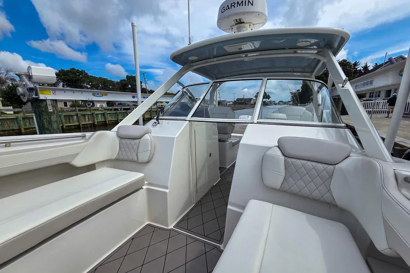 Slide: The Image of 2024 World Cat 296DC boat interior with cushioned seating and Garmin equipment. - 31