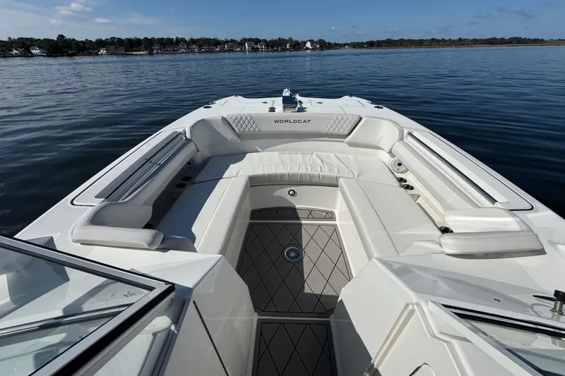 Slide: The Image of 2024 World Cat 296 DC boat interior with spacious seating on calm water. - 34