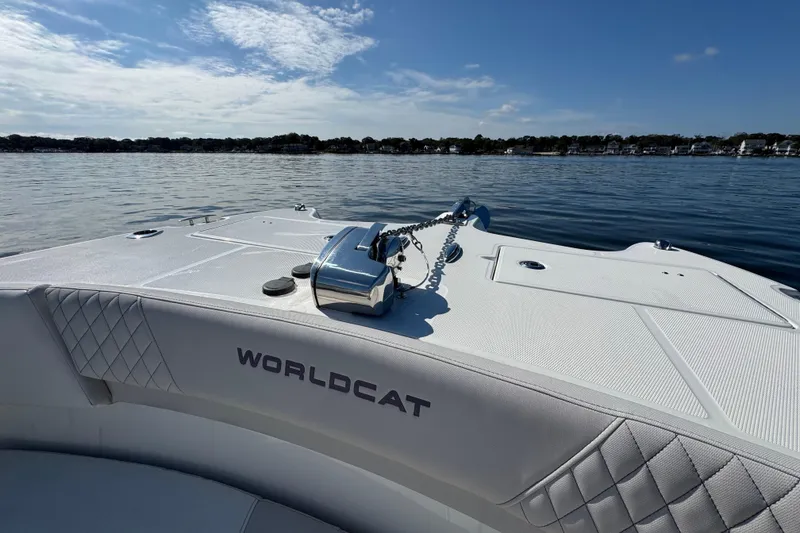 Slide: The Image of 2024 World Cat 296 DC boat on calm water, showcasing sleek design and anchor chain. - 35