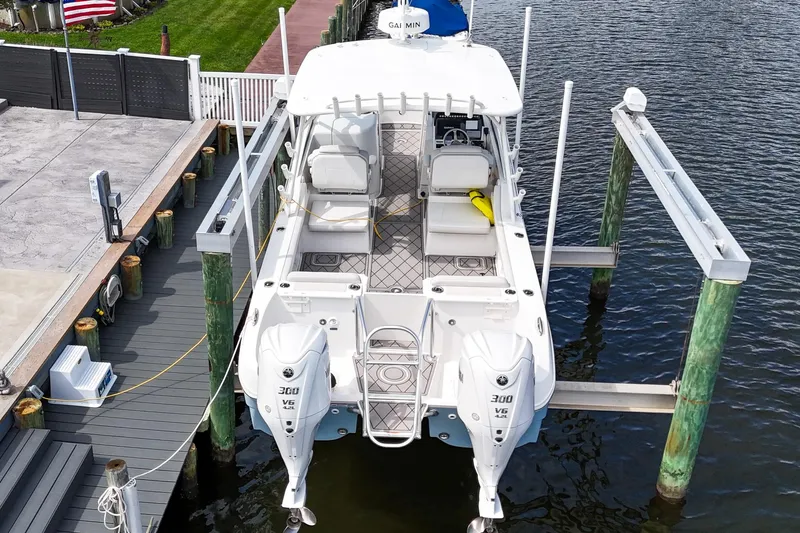 Slide: The Image of 2024 World Cat 296DC boat with twin Yamaha 300 V6 engines docked by the water. - 7