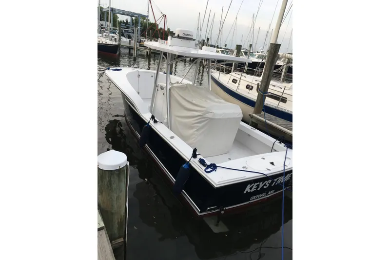 Slide: The Image of 2013 Composite Yacht 26 docked in marina, featuring sleek design and covered seating area. - 13