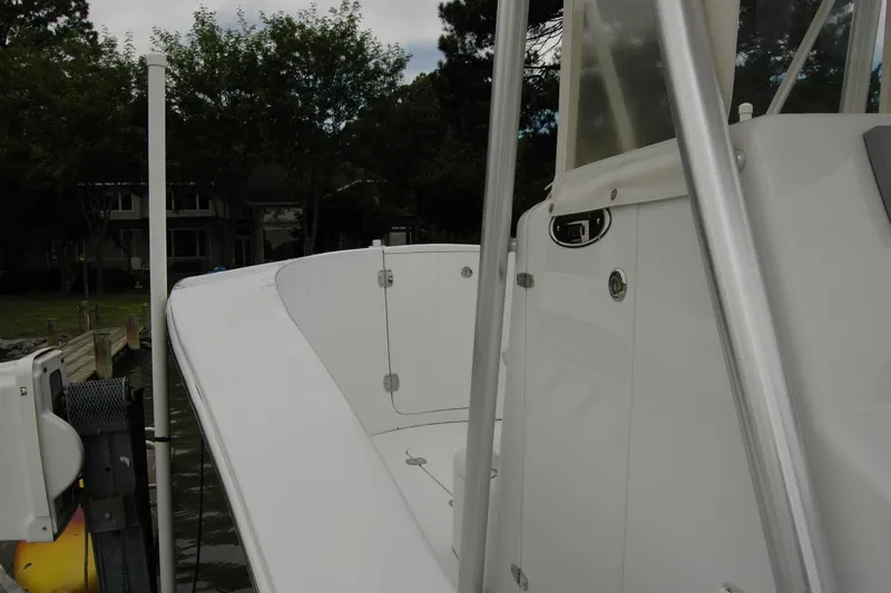 Slide: The Image of 2013 Composite Yacht 26, white deck view, docked near waterfront homes. - 14
