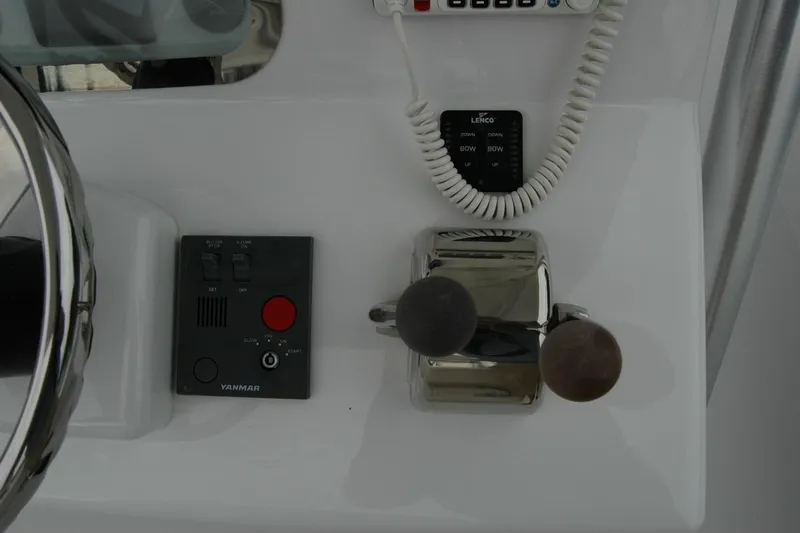 Slide: The Image of Control panel of a 2013 Composite Yacht 26, featuring steering and throttle controls. - 49