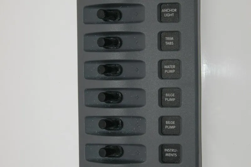 Slide: The Image of Control panel of a 2013 Composite Yacht 26 with labeled switches for various functions. - 52