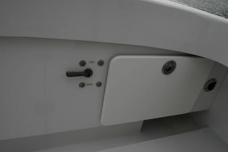 Slide: The Image of Control panel on a 2013 Composite Yacht 26, featuring switches and storage compartment. - 61