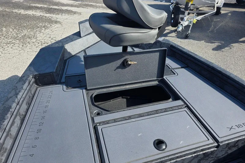 Slide: The Image of 2026 Xpress X18DB boat deck with storage compartment and seat. - 13