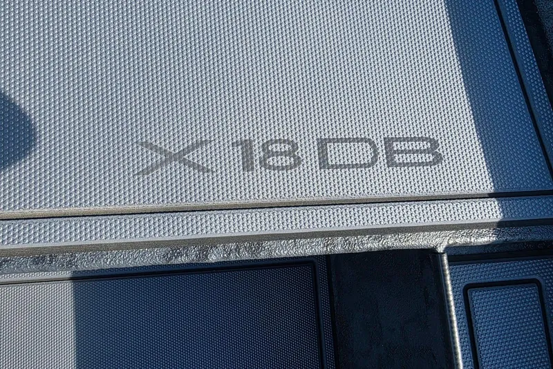 Slide: The Image of 2026 Xpress X18DB boat deck with textured surface and model branding. - 15