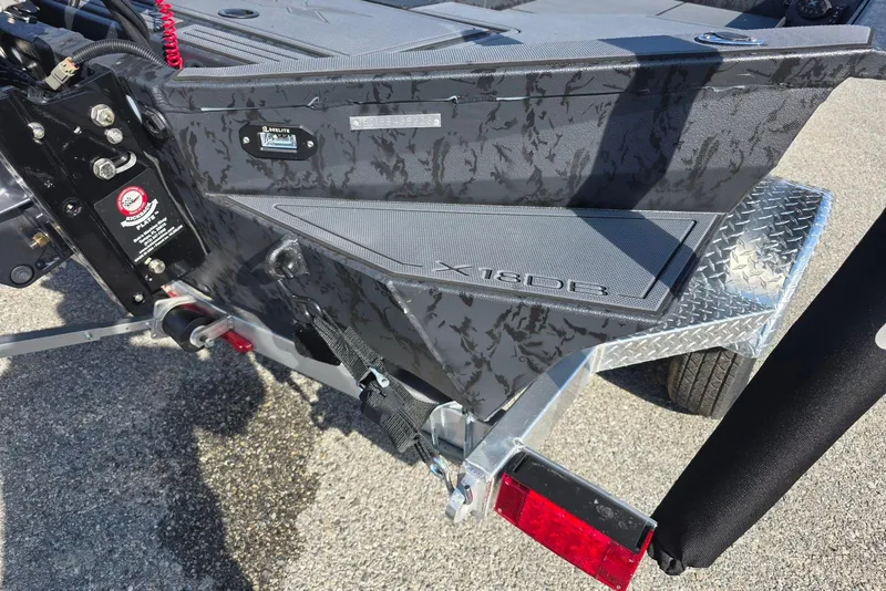 Slide: The Image of 2026 Xpress X18DB boat rear view with textured design and trailer details. - 8