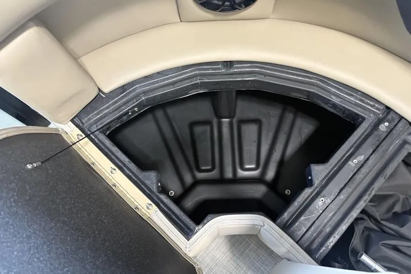 Slide: The Image of Open storage compartment in 2026 Premier 220 Sunscape RF boat, featuring beige and black interior. - 10