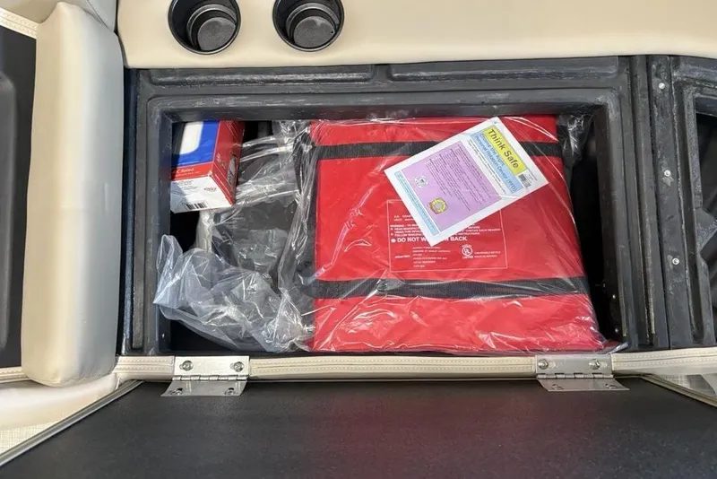 Slide: The Image of Storage compartment in 2026 Premier 220 Sunscape RF with safety equipment and supplies. - 14