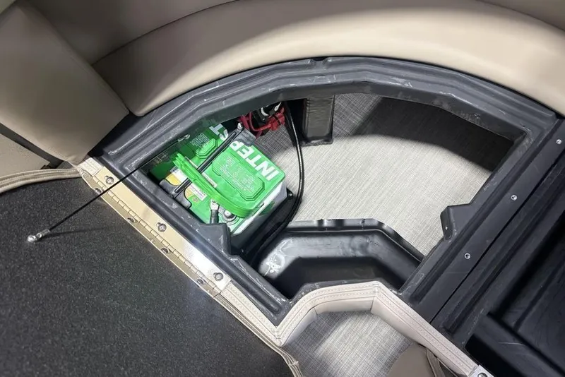 Slide: The Image of Battery compartment of 2026 Premier 220 Sunscape RF boat, featuring green Interstate battery. - 25