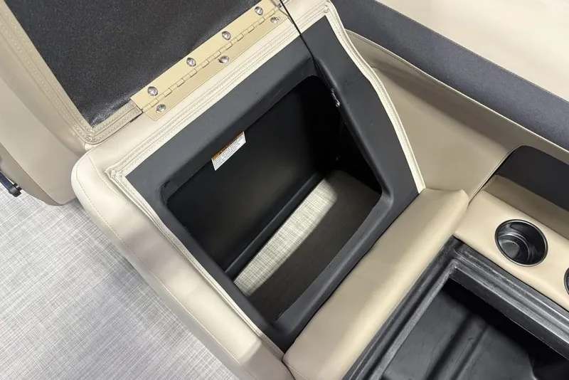 Slide: The Image of 2026 Premier 220 Sunscape RF boat storage compartment with beige upholstery and cup holders. - 30