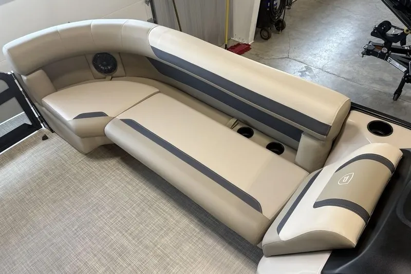 Slide: The Image of 2026 Premier 220 Sunscape RF boat interior with beige and gray seating, cup holders, and speaker. - 4