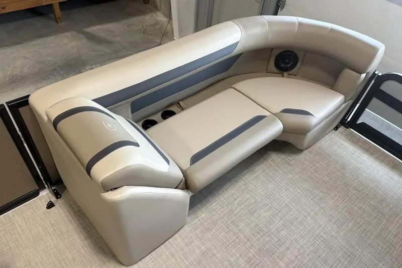 Slide: The Image of 2026 Premier 220 Sunscape RF boat interior with beige and gray seating, cup holders, and speaker. - 7