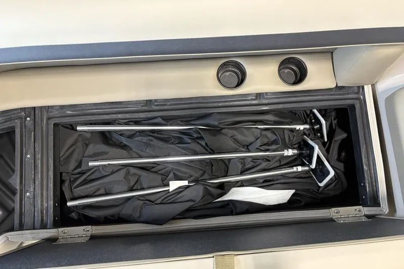 Slide: The Image of Storage compartment in 2026 Premier 220 Sunscape RF boat with metal poles and black cover. - 8