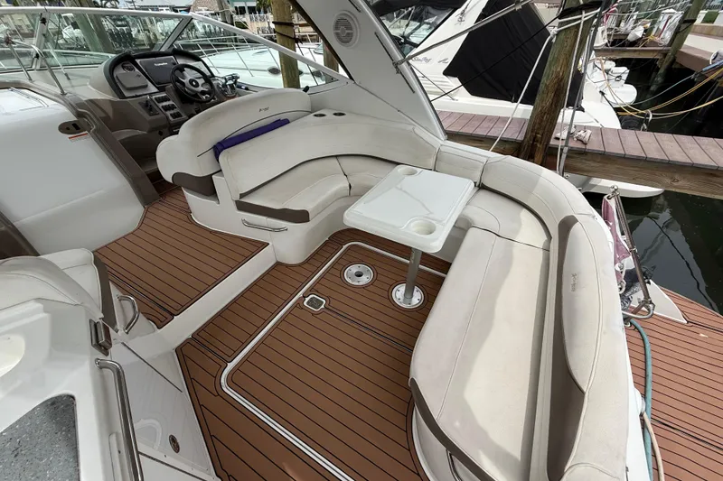 Slide: The Image of 2008 Cruisers Yachts 330 Express interior with plush seating and wooden deck. - 10
