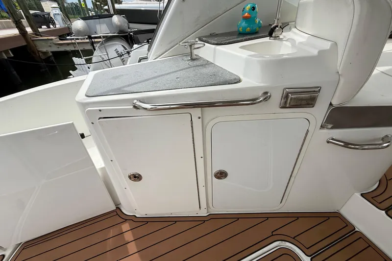 Slide: The Image of 2008 Cruisers Yachts 330 Express boat deck with sink and storage area. - 11