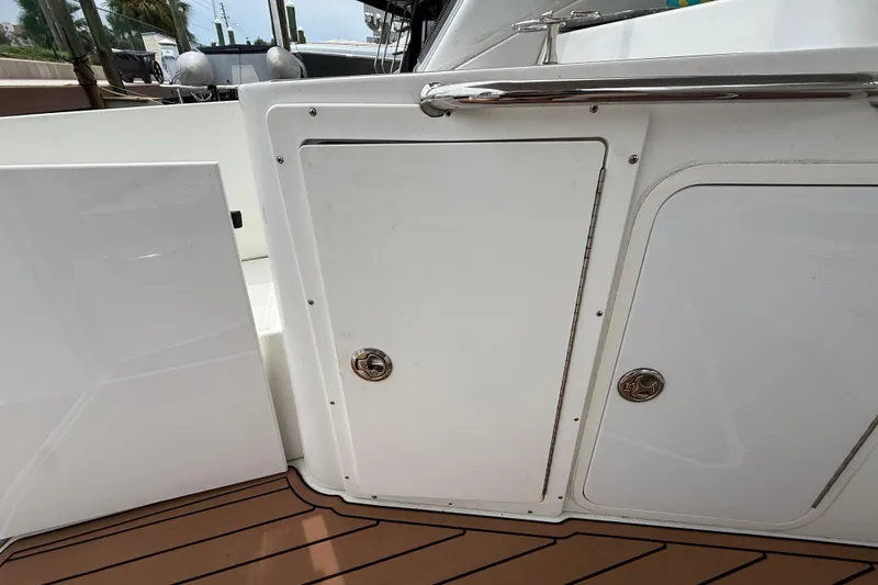Slide: The Image of 2008 Cruisers Yachts 330 Express boat deck with storage compartments and teak flooring. - 12