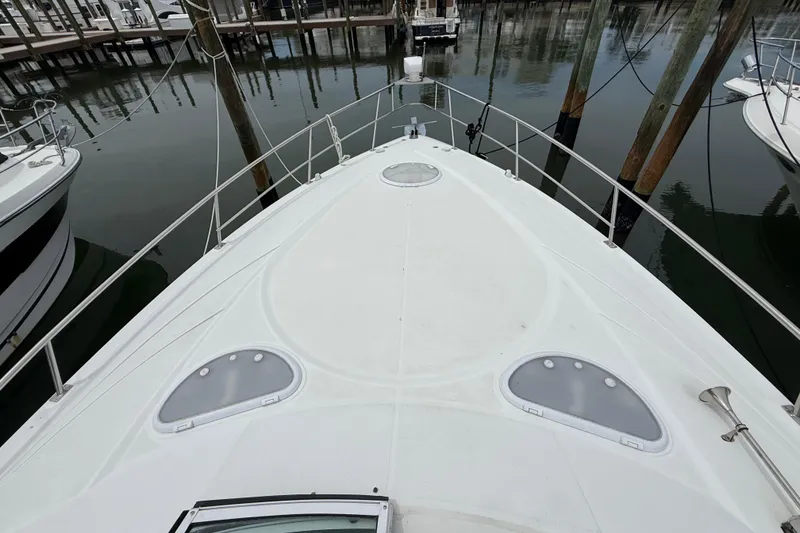 Slide: The Image of 2008 Cruisers Yachts 330 Express boat deck at marina, showcasing sleek design and spacious layout. - 28