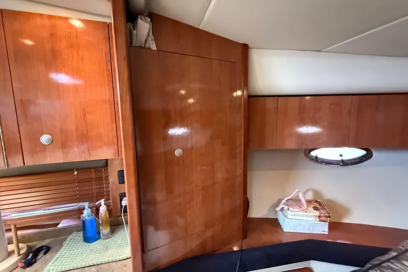 Slide: The Image of 2008 Cruisers Yachts 330 Express interior with wooden cabinetry and porthole window. - 48