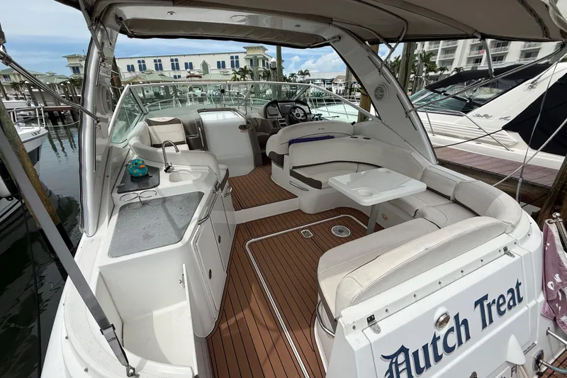 Slide: The Image of 2008 Cruisers Yachts 330 Express interior with seating, table, and helm at marina. - 8