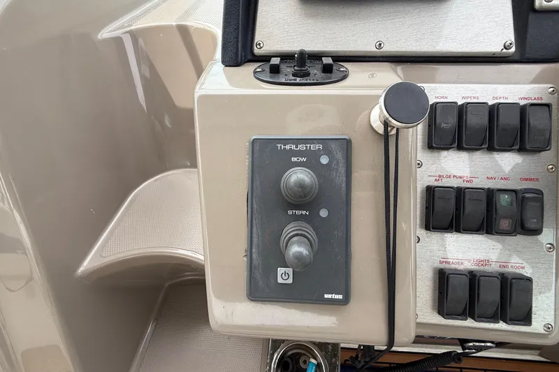 Slide: The Image of Control panel of a 2008 Cruisers Yachts 330 Express, featuring thruster and switch controls. - 22