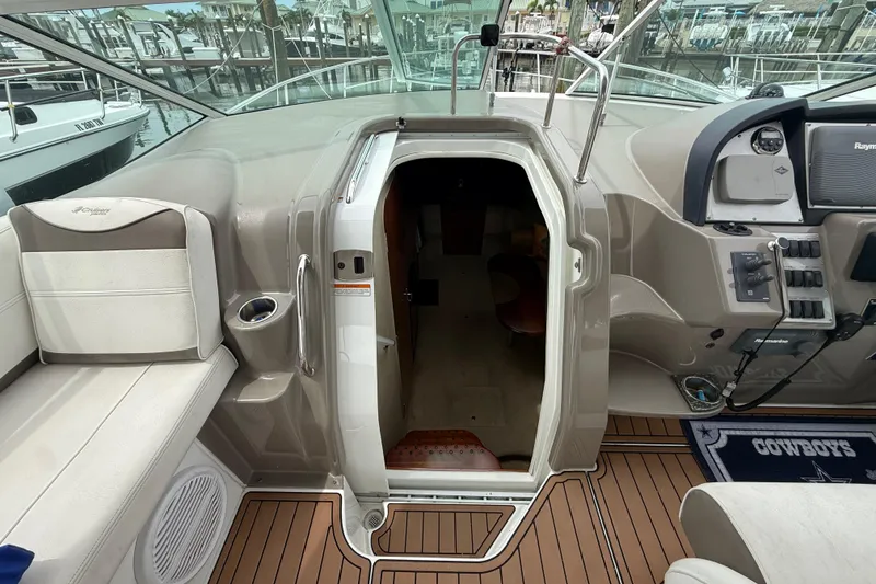 Slide: The Image of 2008 Cruisers Yachts 330 Express cockpit with open cabin door and control panel. - 35