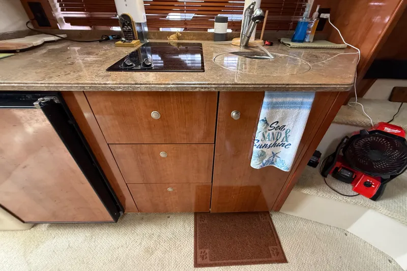 Slide: The Image of 2008 Cruisers Yachts 330 Express kitchen with wooden cabinets, sink, and countertop. - 42