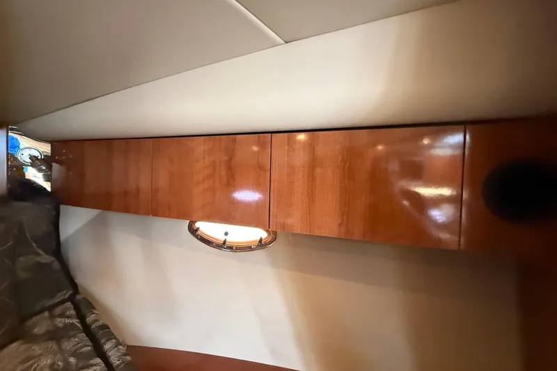 Slide: The Image of 2008 Cruisers Yachts 330 Express interior with wooden cabinets and porthole window. - 47