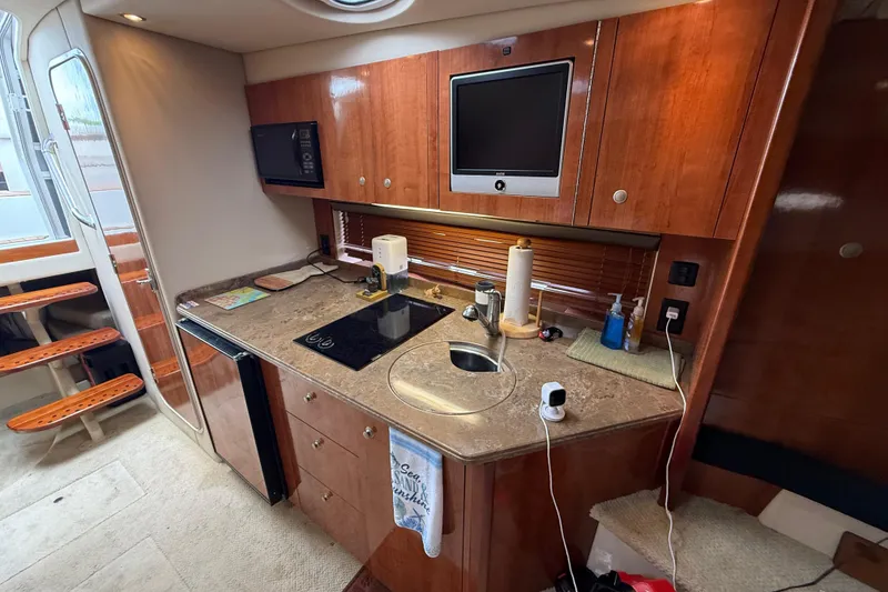 Slide: The Image of 2008 Cruisers Yachts 330 Express interior kitchen with wood cabinetry and modern appliances. - 50