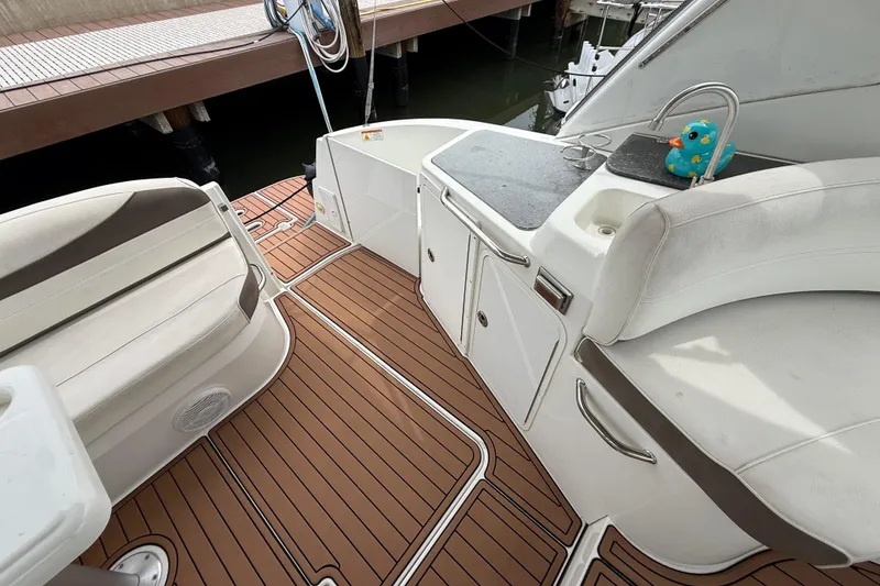 Slide: The Image of 2008 Cruisers Yachts 330 Express deck with seating, sink, and wooden flooring. - 58