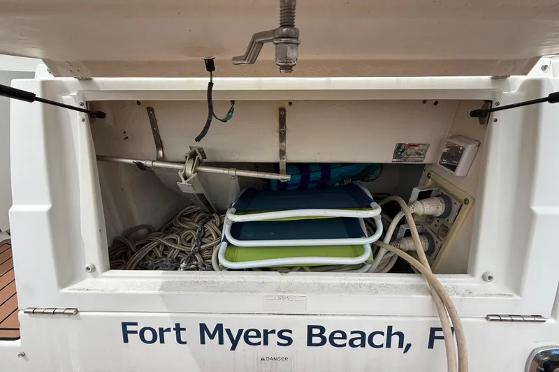 Slide: The Image of 2008 Cruisers Yachts 330 Express storage compartment with ropes and chairs, Fort Myers Beach. - 6