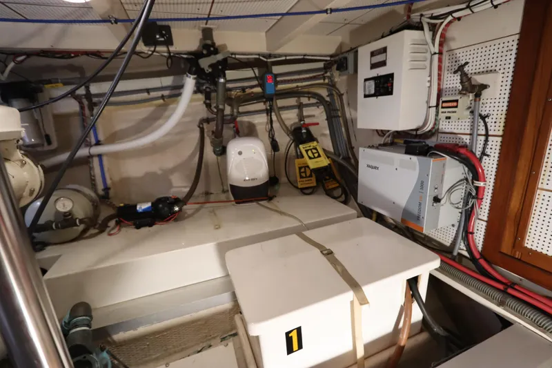 Slide: The Image of Engine room of a 1993 Grand Banks 46 Classic yacht, showcasing equipment and wiring. - 100