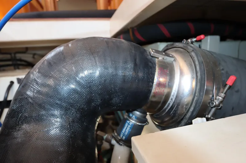 Slide: The Image of Engine room detail of a 1993 Grand Banks 46 Classic yacht, featuring a large exhaust hose. - 122