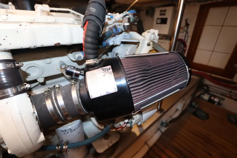 Slide: The Image of Engine compartment of 1993 Grand Banks 46 Classic yacht, featuring air filter and hoses. - 123
