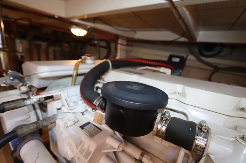 Slide: The Image of Engine room of 1993 Grand Banks 46 Classic yacht, showcasing mechanical components and piping. - 124