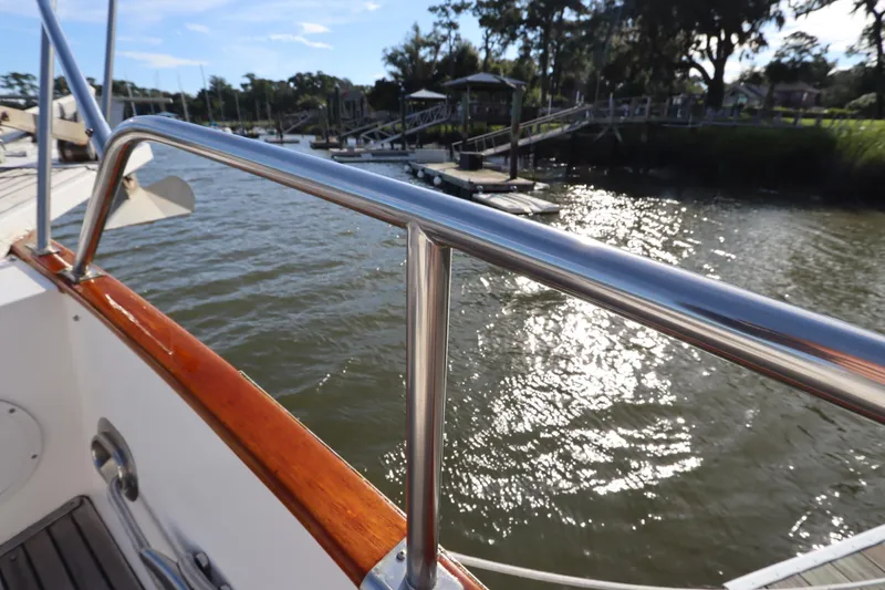 Slide: The Image of 1993 Grand Banks 46 Classic yacht railing with scenic waterfront view. - 16