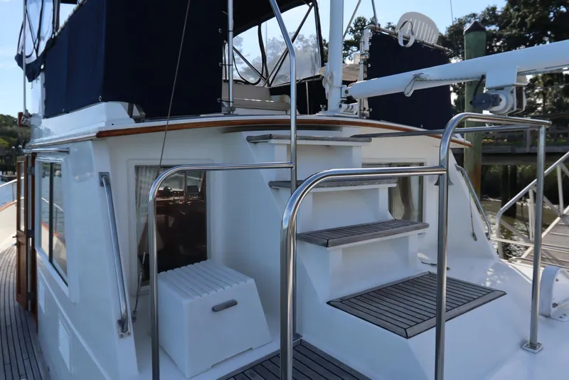 Slide: The Image of 1993 Grand Banks 46 Classic yacht with blue canopy and wooden deck stairs. - 20