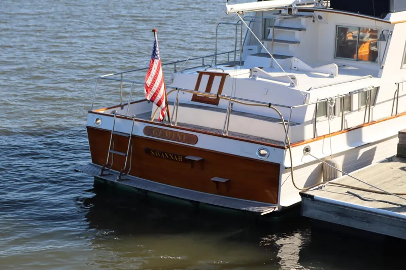 Slide: The Image of 1993 Grand Banks 46 Classic yacht docked, displaying an American flag. - 3