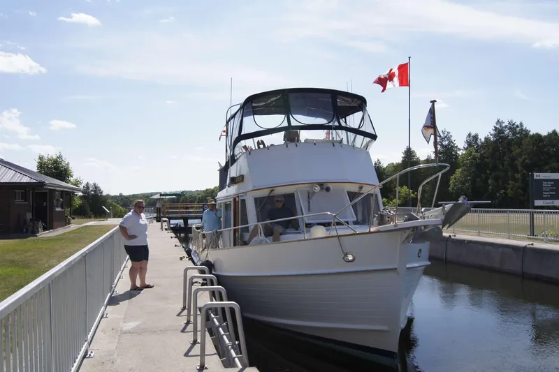 Slide: The Image of 1993 Grand Banks 42 Classic yacht docked at a canal with Canadian flags. - 4