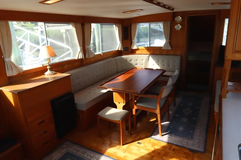 Slide: The Image of Luxurious 1993 Grand Banks 46 Classic yacht interior with elegant dining area and wooden furnishings. - 56