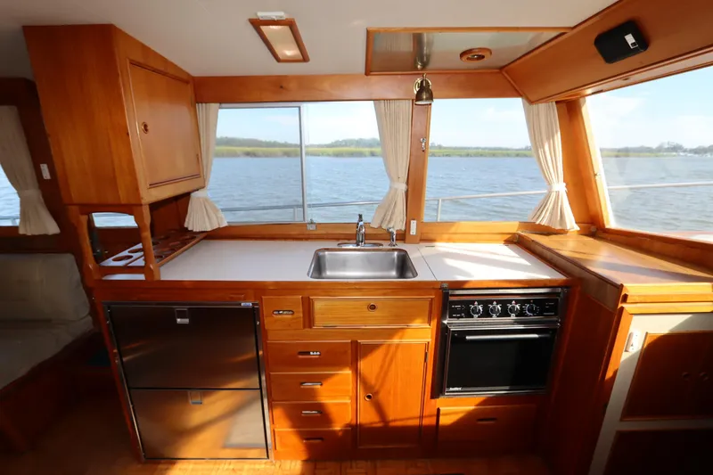 Slide: The Image of Kitchen interior of 1993 Grand Banks 46 Classic yacht with wood cabinetry and water view. - 58