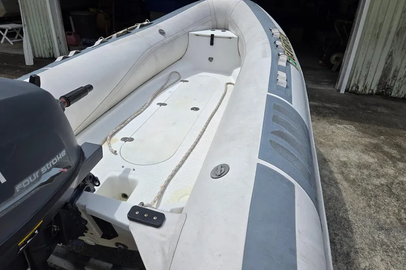 Slide: The Image of Inflatable boat with outboard motor, viewed from the stern, on a concrete surface. - 6